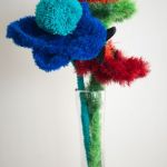 Bouquet de fleurs bleues, rouges et vertes dans un vase de verre